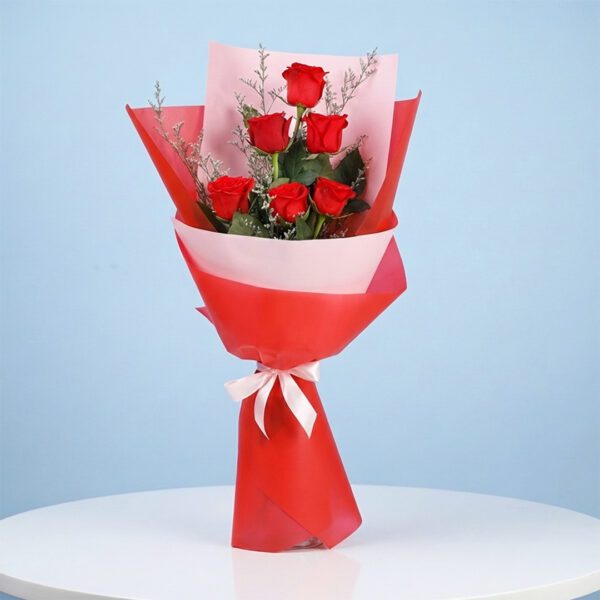 6-red-rose-bouquet-2026 A bouquet of six red roses elegantly wrapped in paper, showcasing their vibrant color and fresh appearance.