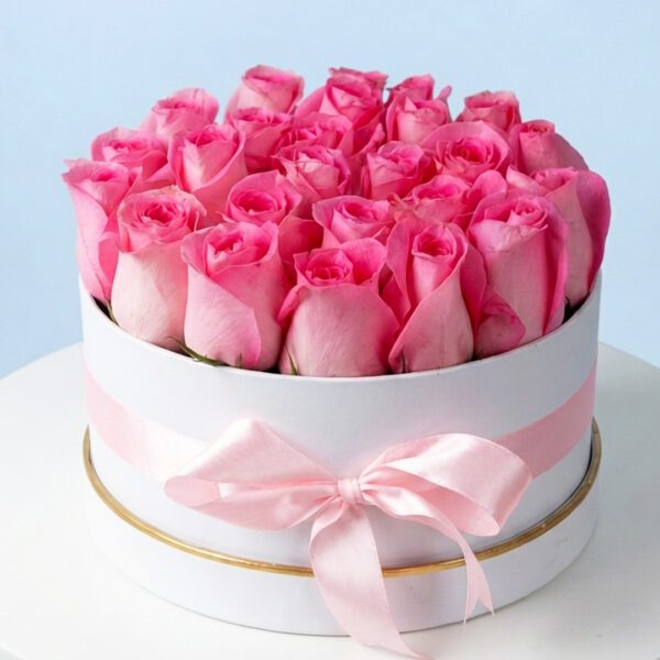 A round box filled with pink roses, elegantly tied with a pink ribbon, labeled as pink lush flowers.