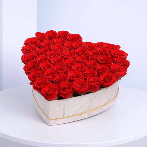 A heart-shaped box filled with vibrant red roses, symbolizing love and affection.