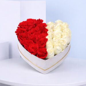 A heart-shaped arrangement of red and white roses, symbolizing love and affection, set against a neutral background.