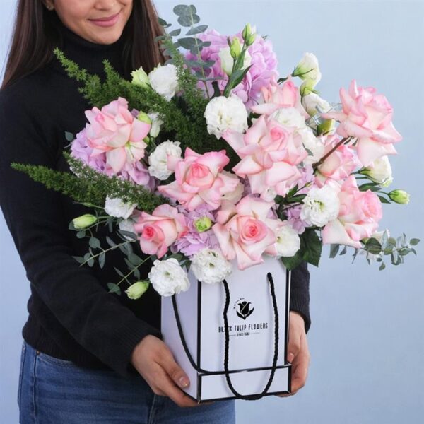 A floral arrangement featuring 10 stems of roses, 5 stems of hydrangeas, and 10 stems of lisianthus with green leaves.