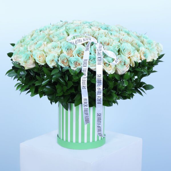 Green box with 75 tinted Harmony roses and Ruscus bunches, perfect gift arrangement.