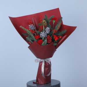 Red and silver Holiday bouquet with red flowers, silver pinecones, and greenery wrapped in burgundy paper and a silver ribbon.