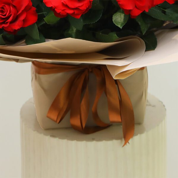 50 Red Rose Bouquet wrapped in beige paper with a satin ribbon