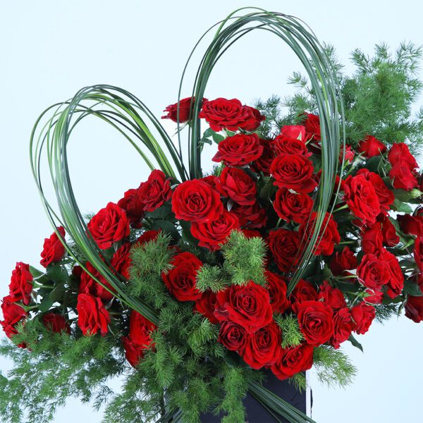 A romantic arrangement of 20 baby red roses and asparagus leaves, perfect for any special occasion.