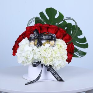 Valentine’s Day flower box with red and white blooms, heart-shaped grass centerpiece, and Ferrero Rocher chocolates