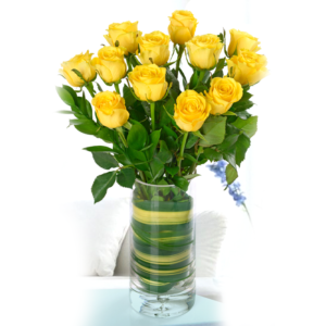A classic bouquet of a dozen yellow roses arranged in a clear glass vase with decorative green leaves.