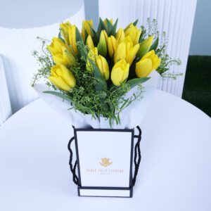 A vibrant collection of yellow tulips elegantly placed in a sleek box.
