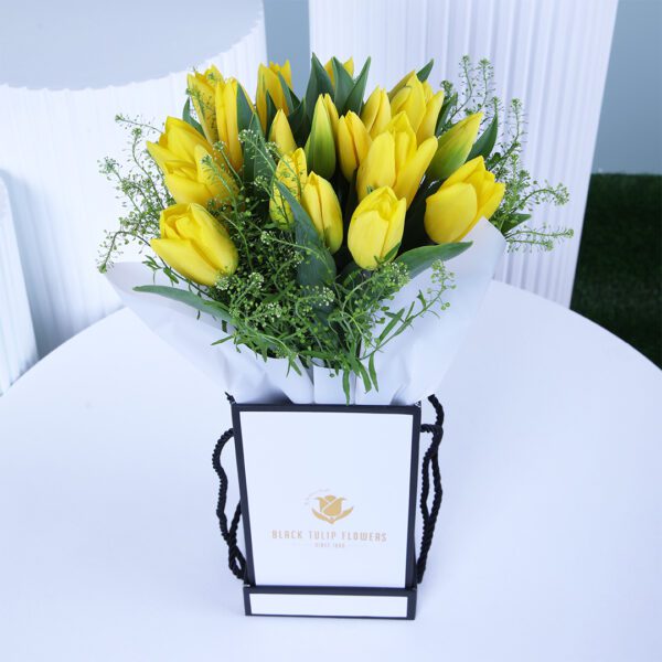 A vibrant collection of yellow tulips elegantly placed in a sleek box.