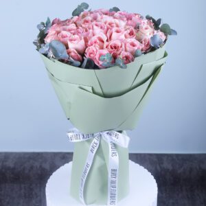 Bouquet of 50 fresh pink roses wrapped in sage green paper with white ribbon