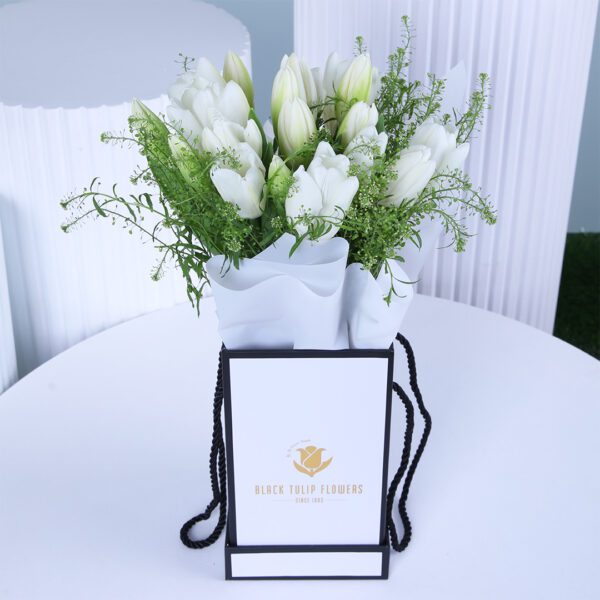A fresh bundle of white tulips, wrapped in white and presented in an elegant gift box.
