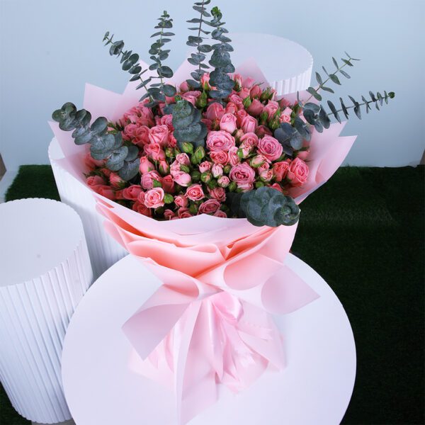 Bouquet of fresh pink spray roses mixed with eucalyptus.