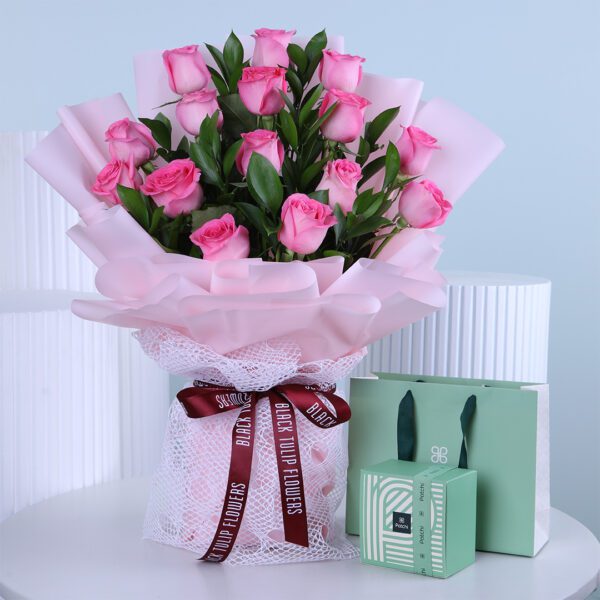 Pink rose bouquet with soft pink wrapping and a mint green Patchi gift box.