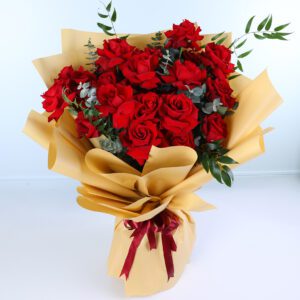 Bouquet of 15 red roses with green foliage wrapped in elegant golden paper