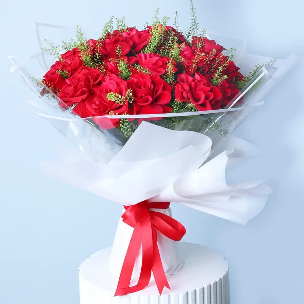 20 red roses with thalaspi in white wrapping, finished with a ribbon.