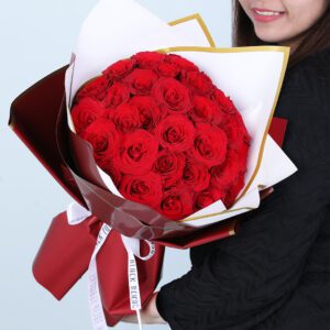 30 vibrant red roses are elegantly arranged to create a luxurious, romantic floral setup in a maroon wrap.