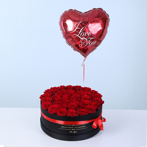 Black round floral box showcasing fresh roses, finished with a red bow and a romantic heart-shaped balloon