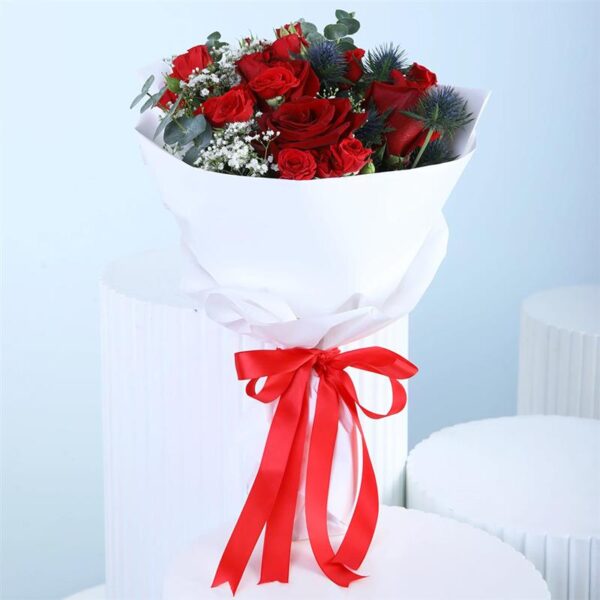 tokens-of-red-love-rose-bouquet A bouquet featuring 4 red roses, 3 spray roses, and 2 stems of fresh greenery, combining vibrant blooms and lush foliage in a harmonious, beautifully arranged floral display.