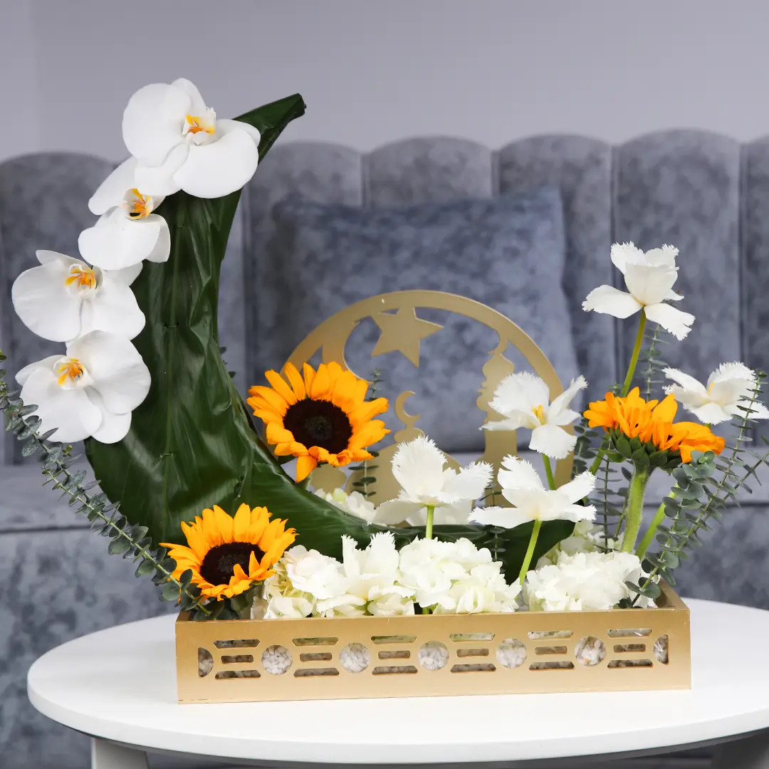 A floral centerpiece with bright sunflowers and elegant orchids arranged on a table.