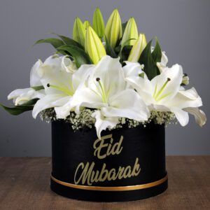 A black box with white lilies and sophisticated gold lettering.